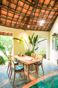 Lara Homestay في Ấp Gò Dinh: غرفة طعام مع طاولة وكراسي خشبية