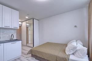 a bedroom with a bed and a kitchen with a sink at Apart-hotel Magestic EVN Airport in Pʼarakʼar