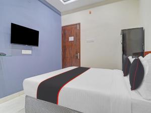 a bedroom with a bed and a tv on the wall at HOTEL PNR SUITES KUKATPALLY in Hyderabad