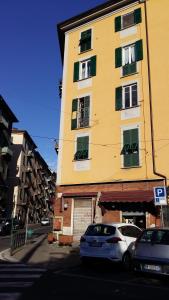 un edificio amarillo con coches estacionados frente a él en L'affresco, en La Spezia
