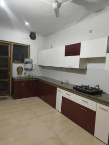 a kitchen with brown and white cabinets and a stove at Quiet Haven in Panchkula +12 photos