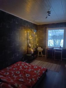 Un dormitorio con una cama roja y una ventana. en Resort Selekosten Tunto, en Rovaniemi