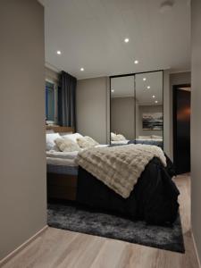 una camera da letto con un letto e un grande specchio di ArticLoft Kemi a Kemi