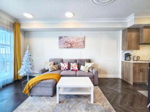 a living room with a couch and a christmas tree at Family Stylish 2BR Condo with City View, DT, Balcony, Free Parking & In-Suite Laundry! in Calgary