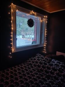 Un dormitorio con una ventana con una corona y luces. en Resort Selekosten Tunto, en Rovaniemi