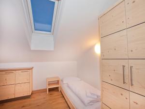 Un dormitorio pequeño con una cama y una ventana. en Apartment in Wald im Pinzgau with Swimming Pool and Views, en Wald im Pinzgau