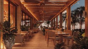 a restaurant with tables and chairs and the ocean at Alila Mayakoba in Playa del Carmen