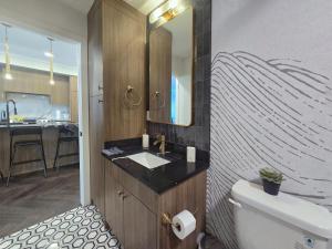 a bathroom with a sink and a mirror at Family Stylish 2BR Condo with City View, DT, Balcony, Free Parking & In-Suite Laundry! in Calgary +54 photos
