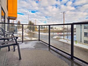 a balcony with a bench and a view of a street at Family Stylish 2BR Condo with City View, DT, Balcony, Free Parking & In-Suite Laundry! in Calgary