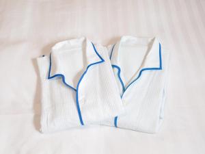 three white socks sitting on a white bed at Comfort Hotel Tendo in Tendo