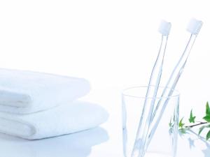 two toothbrushes in a glass next to a stack of towels at Comfort Hotel Tendo in Tendo +19 photos