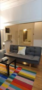 un divano blu in soggiorno con un tappeto colorato di KarenResidence a Cabramatta