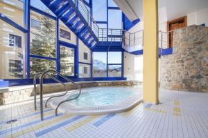 a swimming pool in a house with blue ceilings at Appartamenti presso Hotel Europa in St. Moritz