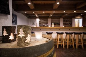 a bar with a table with a candle and stools at Appartamenti presso Hotel Europa in St. Moritz