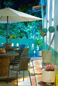 a patio with chairs and a table with an umbrella at Hostal Prana in Abejorral