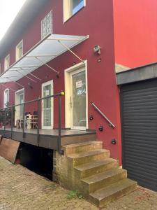 un edificio rojo con escaleras que conducen a una puerta en Apartment nah Flughafen, Messe, Arena, Dome, en Düsseldorf