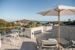 un patio con tavolo, sedie e ombrellone di Villa Life ad Agia Marina Nea Kydonias