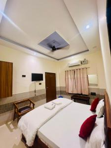 Un dormitorio con una gran cama blanca con almohadas rojas. en Gitanshi Palace, en Jāmb