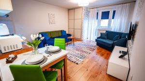 a living room with a table and green chairs at Park Sportowy, Sun & Snow in Krynica Zdrój