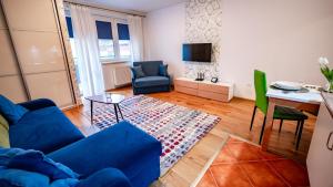 a living room with a blue couch and a table at Park Sportowy, Sun & Snow in Krynica Zdrój