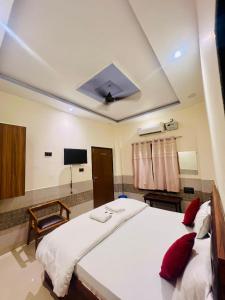 Un dormitorio con una gran cama blanca con almohadas rojas. en Gitanshi Palace, en Jāmb