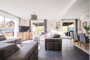 Una sala de estar con sofás y una mesa y sillas. en Maison Jarrier, en Saint-Jean-de-Maurienne