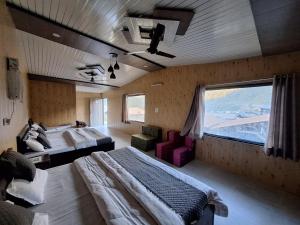 a large bedroom with two beds and a window at Valley King Resort in Rishīkesh