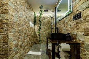 un baño con una pared de piedra en ALBERT RESIDENCE Brasov Historical City Center, en Brasov 65 fotos más