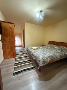 a bedroom with a bed and a wooden door at Pensiunea Popan in Şieu +71 photos