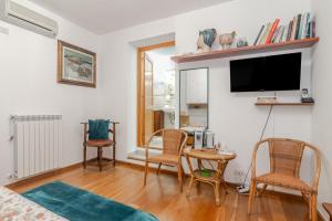 a living room with a table and chairs and a tv at Chicca Di Francesca- Santa Teresa in Santa Teresa Gallura