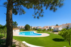 a swimming pool in a yard with a tree at La Réserve-Comporta by Terresens in Comporta
