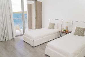 Villa Mariposa Ocean Front Mansion with Infinity Pool في غانيكا: سريرين في غرفة مطلة على المحيط +24 صورة