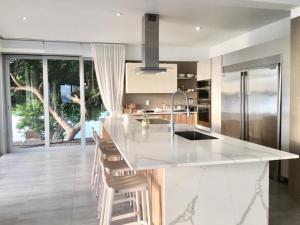 Villa Mariposa Ocean Front Mansion with Infinity Pool في غانيكا: مطبخ مع كونتر أبيض قمة وجزيرة مطبخ