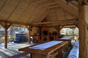 a large wooden pavilion with a fireplace and wooden tables at Cabana Victor in Sighetu Marmaţiei