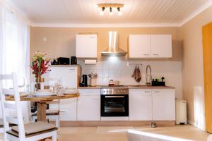 een keuken met witte kasten en een houten tafel bij Ferienwohnung Weideblick Gänsberg in Blaibach