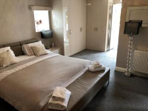a bedroom with a large bed with towels on it at The Oaks A private room in our home With its own entrance with internal doors locked More suited to quieter guests wanting a peaceful stay in Consett