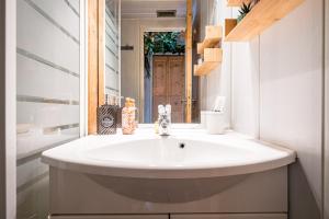 een badkamer met een witte wastafel en een spiegel bij Studio Champ Pérouze in La Toussuire