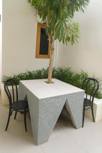 a table with a tree on it with two chairs at Salt & Light Labuan Bajo in Komodo Labuan Bajo Airport +8 photos