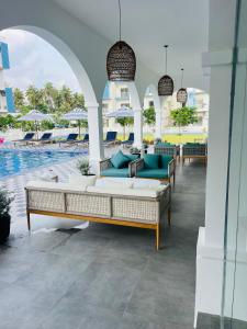 a patio with couches and a pool at a resort at Celestial Negombo Pool View Resort Apartments in Negombo +8 photos