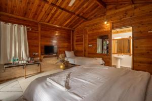 a bedroom with a bed in a room with wooden walls at BOHOA Beach Resort Palolem in Palolem