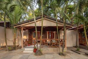 a small house with palm trees in front of it at BOHOA Beach Resort Palolem in Palolem