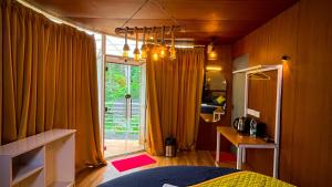 ein Schlafzimmer mit einem Bett und einem großen Fenster in der Unterkunft Zeno Village Resort 900 Kandi Wayanad in Wayanad