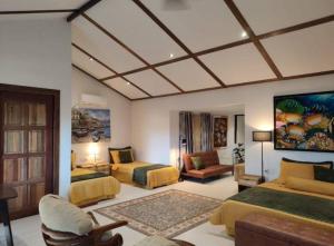 een grote slaapkamer met 2 bedden en een bank bij Jam's Pool Villa Langkawi in Ulu Melaka