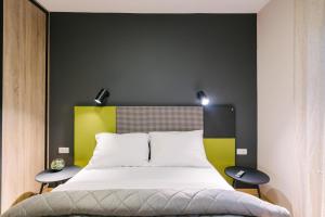 a bedroom with a large bed with two tables at NAR Royalton Apartment #60 in Niš