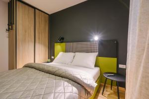 a bedroom with a bed with a yellow and black wall at NAR Royalton Apartment #60 in Niš +3 photos