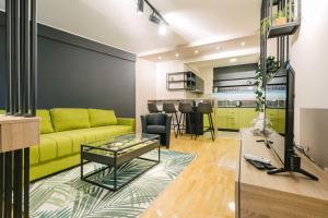 a living room with a yellow couch and a table at NAR Royalton Apartment #60 in Niš