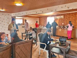 un grupo de personas comiendo en un restaurante en Hotel Royal Residency At Near By International Airport, en Nueva Delhi