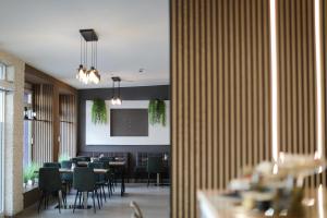 a dining room with tables and chairs and a room with at Hotel Allee 55 in Hannover