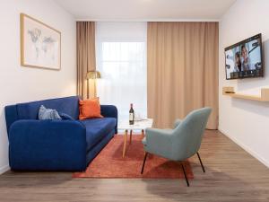 a living room with a blue couch and a table at smartments Hamburg Hamm in Hamburg