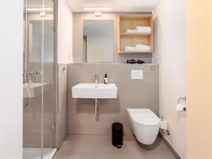 a bathroom with a sink and a toilet and a shower at smartments Hamburg Hamm in Hamburg +24 photos